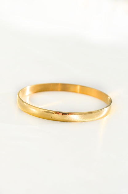 A single 18K PVD Gold Plated Bangle bracelet on a white background. By DBL Jewelry