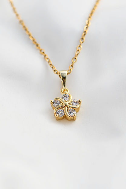 Gold necklace with a butterfly pendant on a light gray background