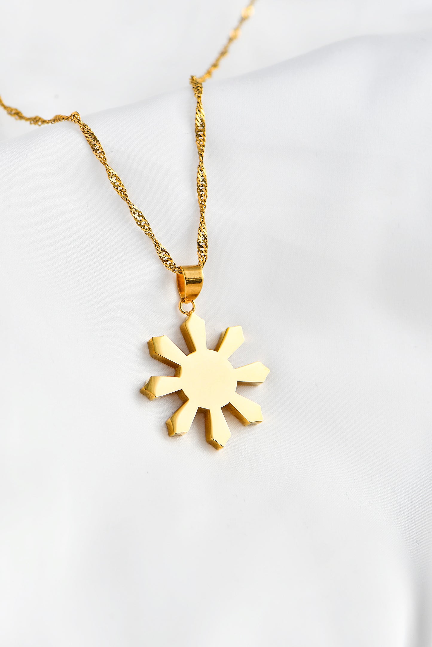 Gold Mabuhay Sun on white background. By DBL Jewelry