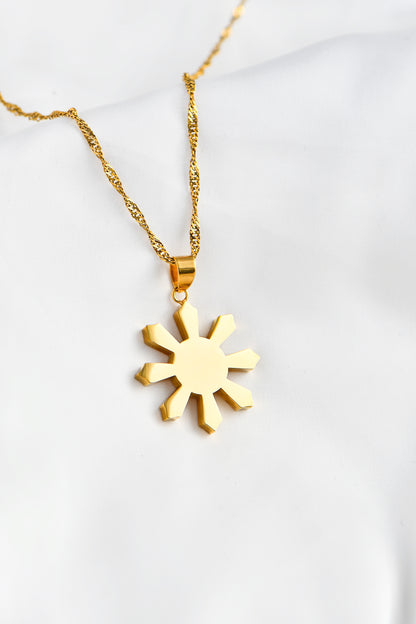 Gold Mabuhay Sun on white background. By DBL Jewelry