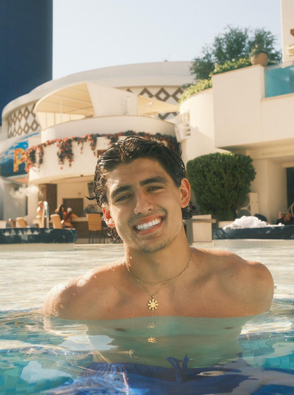 Gold Mabuhay Sun Necklace on Model in a pool, showing it's Waterproof and Non Tarnish. By DBL Jewelry