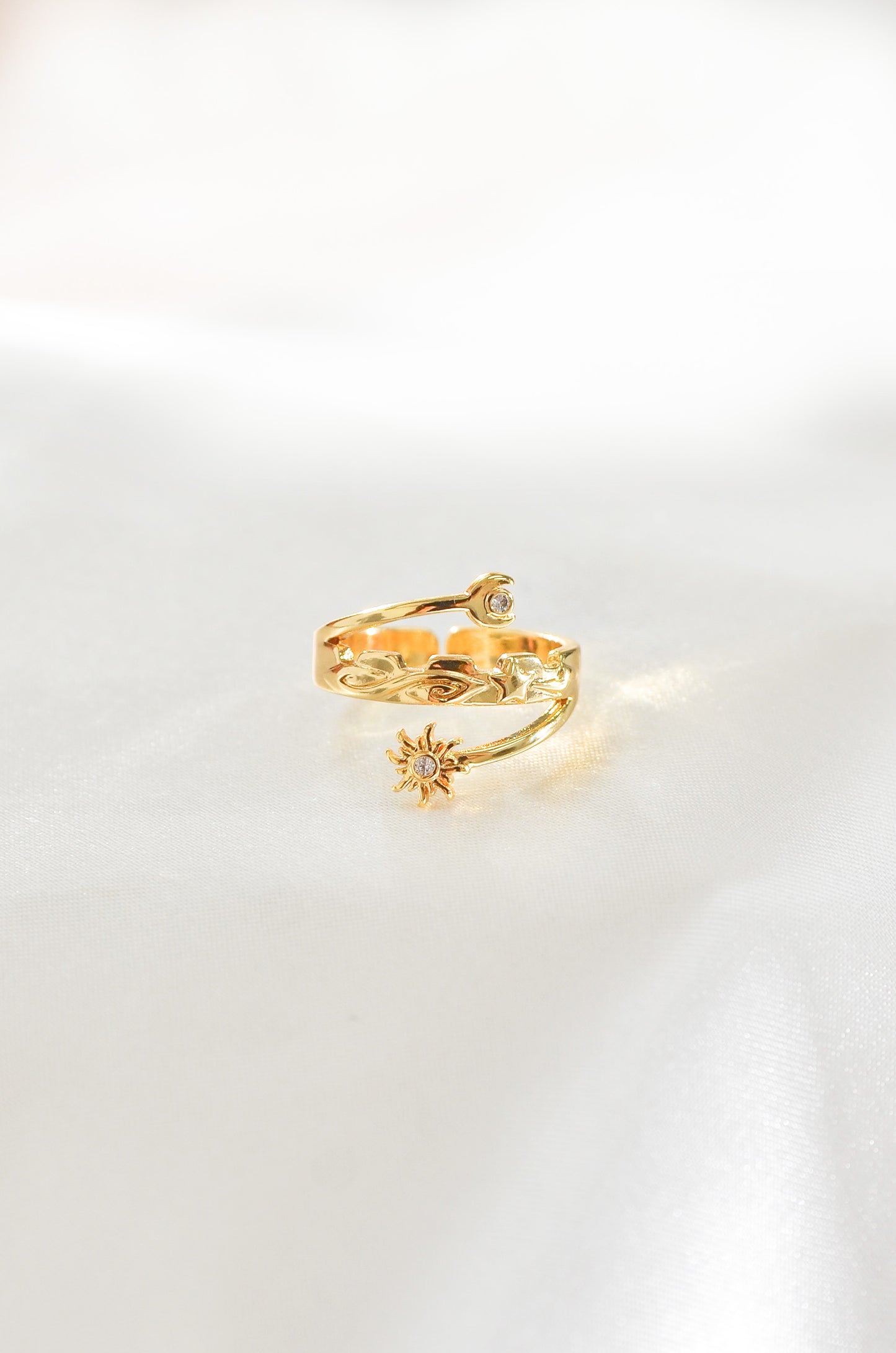 A Golden Eclipse Ring on white background, featuring a moon and sun. By DBL Jewelry