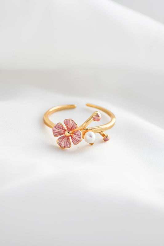 Gold ring with pink floral design and pearl on a white background. By DBL Jewelry
