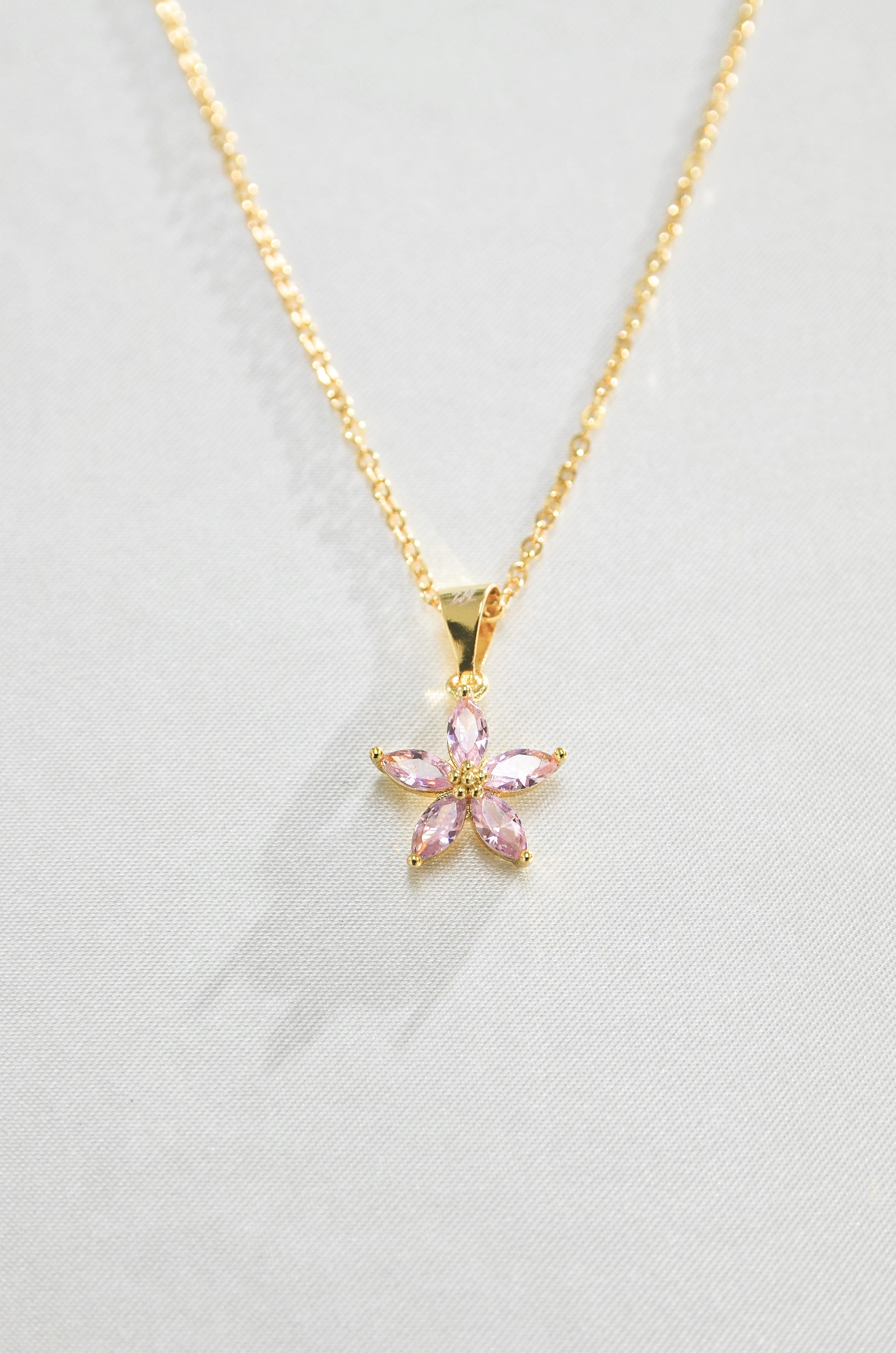 A gold-filled necklace with a pink flower-shaped pendant, a cherry blossom. Covered with 18K Gold Filling, made by DBL